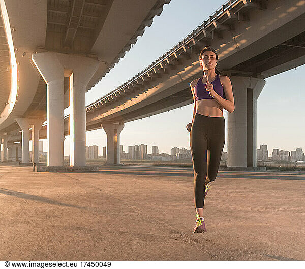 Strong female athlete running in morning