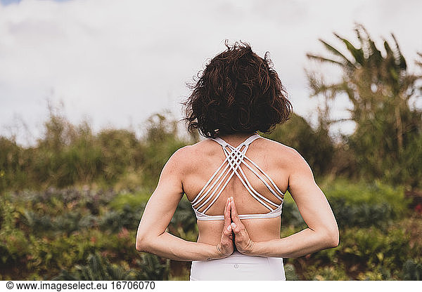 Strong female practices yoga outside in a field