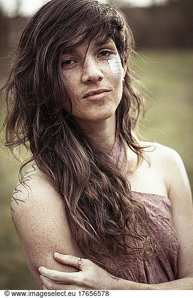 strong natural woman with long wild hair and facepaint
