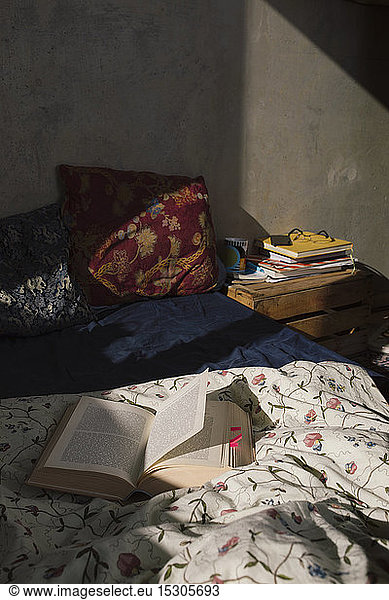 Student's room with open book lying on bed