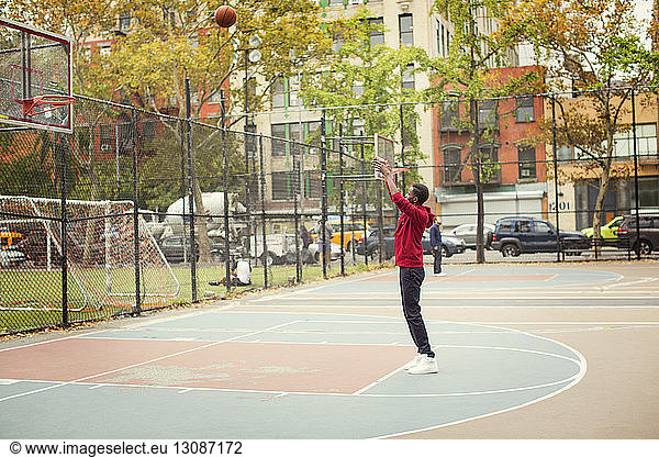Student taking a shot while playing at basketball court
