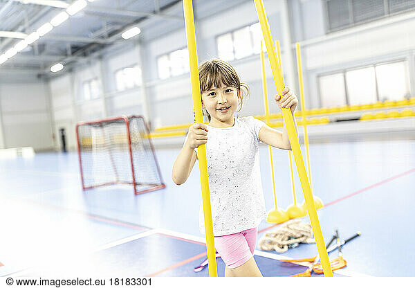 Student walking with exercising poles at school sports court