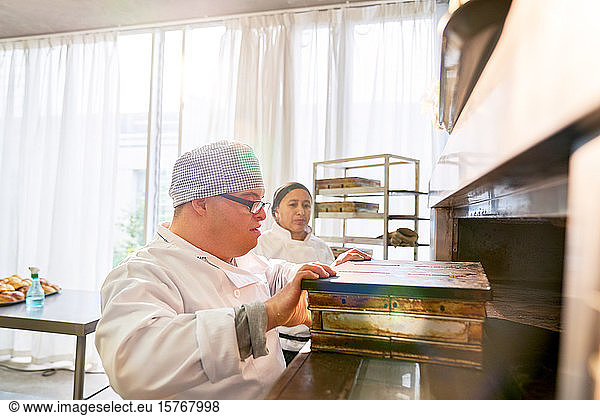 Student with Down Syndrome placing bread box in oven