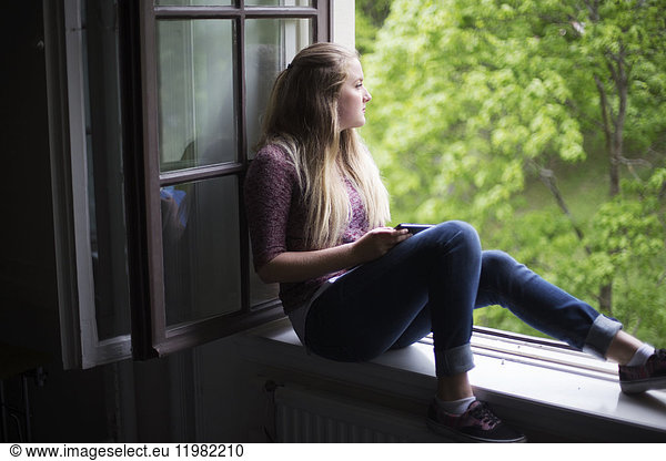Studentin sitzt am Fenster