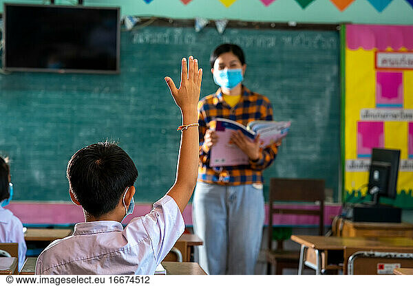 Students and her teacher wearing protective face masks in classr