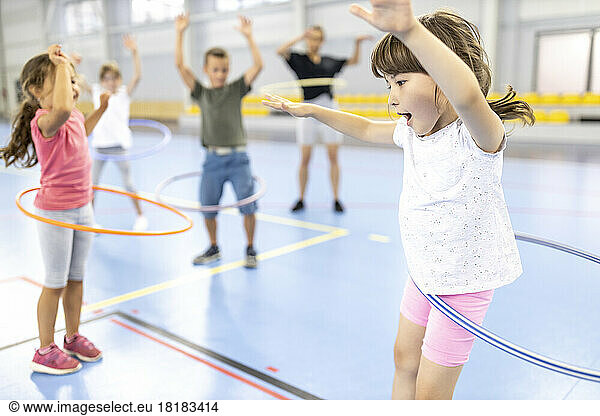 Students practicing hula hoops with each other at school sports court