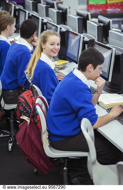 Students smiling  sitting and learning in computer room