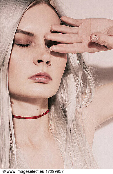 Studio Fashion Portrait Of Blonde Wearing red choker topless.