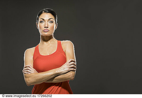 Studio-Porträt einer sportlichen Frau in rotem ärmellosen Oberteil