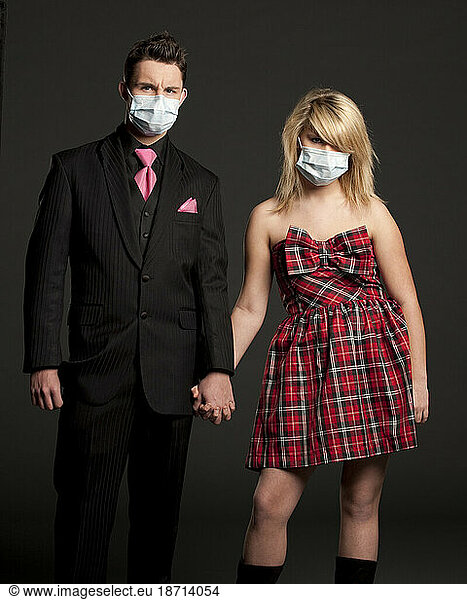 Studio portrait of a teenage Caucasian couple wearing a medical mask.