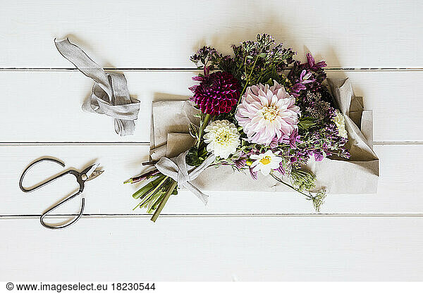 Studio shot of bouquet of three varieties of dahlias mixed with other flowers