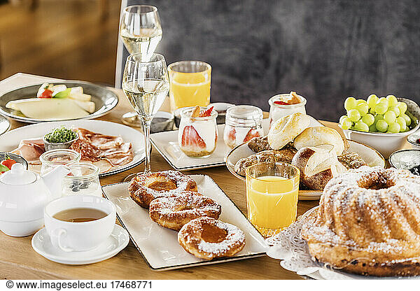 Studio shot of breakfast table filled with various desserts  fruits and vegetables