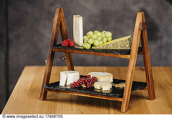 Studio shot of cheese board with various kinds of cheese and raw fruits