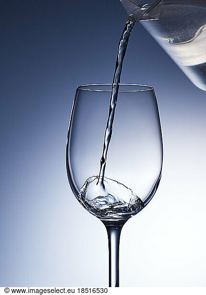 Studio shot of clear water pouring into wineglass