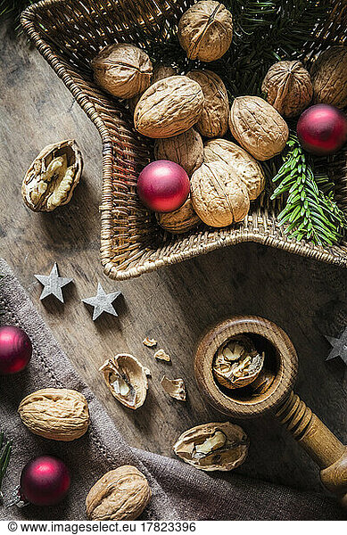 Studio shot of cutting board  star shaped wicker basket  Christmas ornaments  walnuts and simple nutcracker