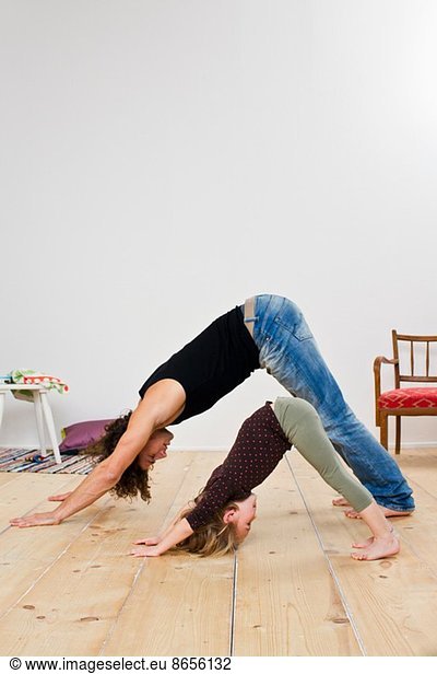Studio shot of father and daughter bending over on floor