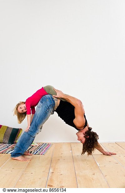 Studio shot of father with daughter bending over on floor
