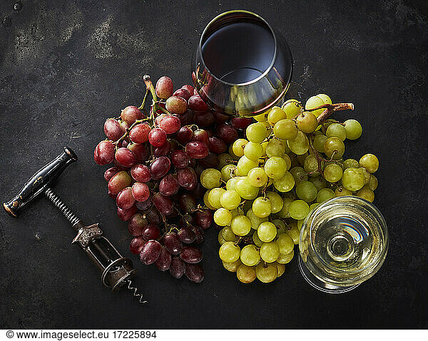 Studio shot of fresh grapes  corkscrew and two glass of red and white wine