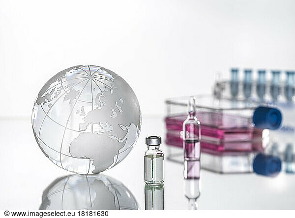 Studio shot of glass globe and medical vials