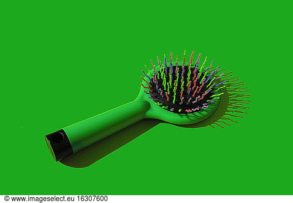 Studio shot of green hairbrush