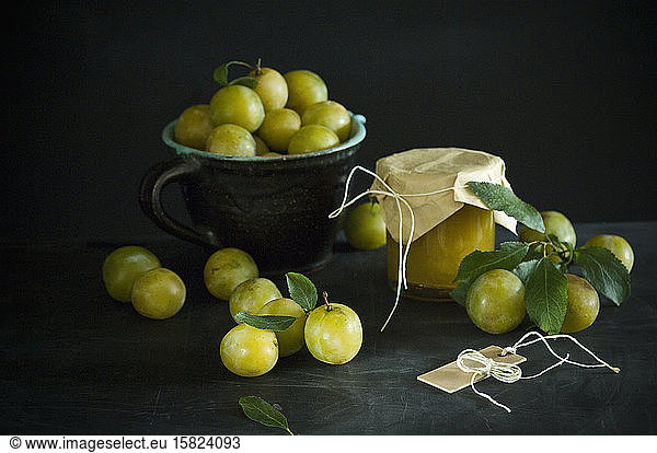 Studio shot of greengages and jar of homemade plum jam
