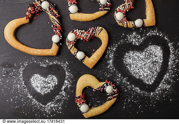 Studio shot of heart shaped cookies flat laid against black background
