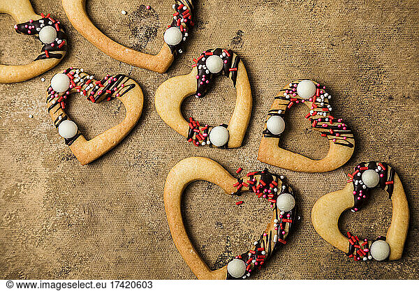 Studio shot of heart shaped cookies flat laid against brown background