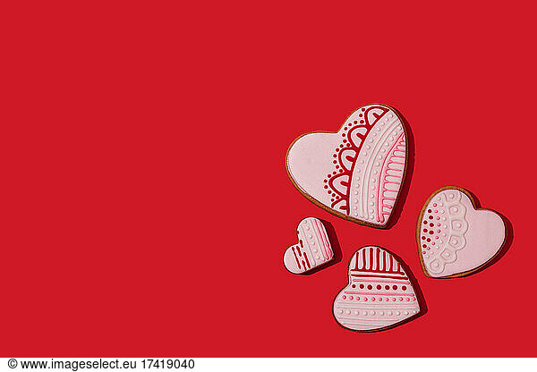 Studio shot of heart shaped cookies flat laid against red background