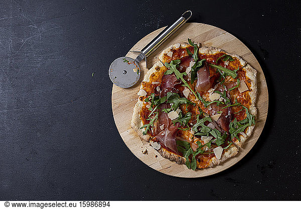 Studio shot of homemade pizza with Mozzarella  ham  arugula and Parmesan