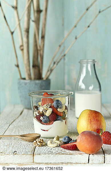 Studio shot of jar of healthy muesli with raw fruits and nuts