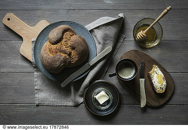 Studio shot of mug of coffee  honey and loaf of homemade pumpkin bread