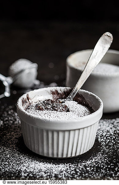 Studio shot of mug of molten chocolate cake with powdered sugar