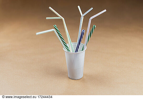 Studio shot of plastic cup with various drinking straws