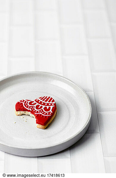 Studio shot of plate with heart shaped cookie missing single bite