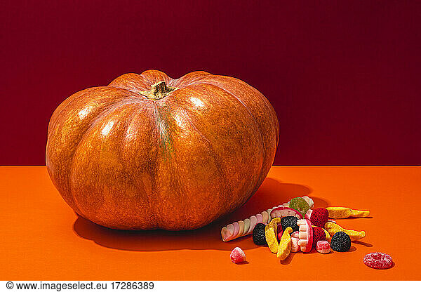 Studio shot of raw pumpkin and Halloween candies