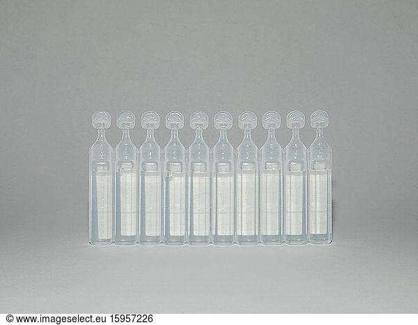 Studio shot of row of plastic vials with transparent liquid
