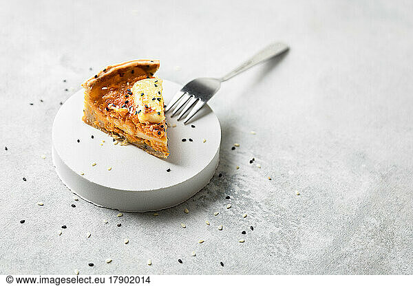 Studio shot of slice of butternut squash pie with sesame seeds