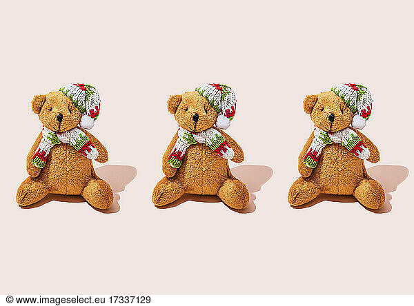 Studio shot of three anthropomorphic teddy bears wearing scarfs and knit hats