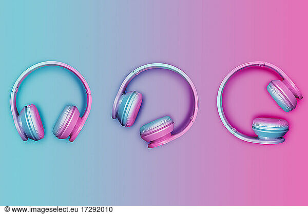 Studio shot of three pairs of pink and blue wireless headphones