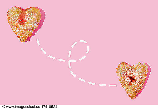 Studio shot of two heart shaped pies connected with dotted line