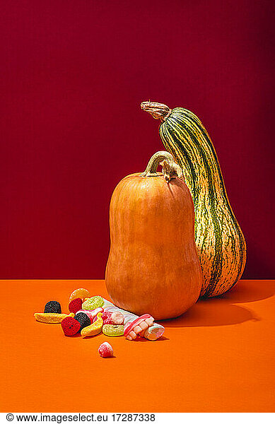Studio shot of two raw pumpkins and Halloween candies