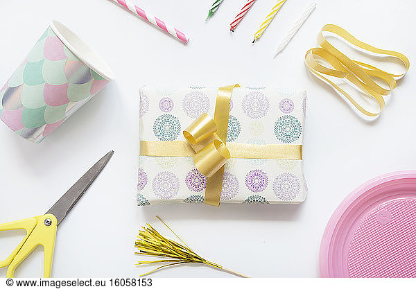 Studio shot of wrapped birthday present and various birthday props