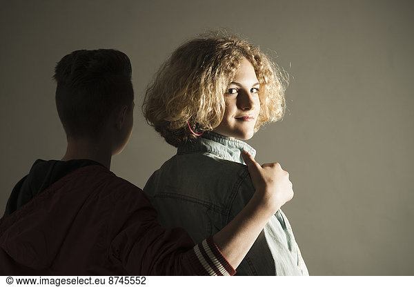 Studioaufnahme  Jugendlicher  sehen  Junge - Person  Arm umlegen  Mädchen