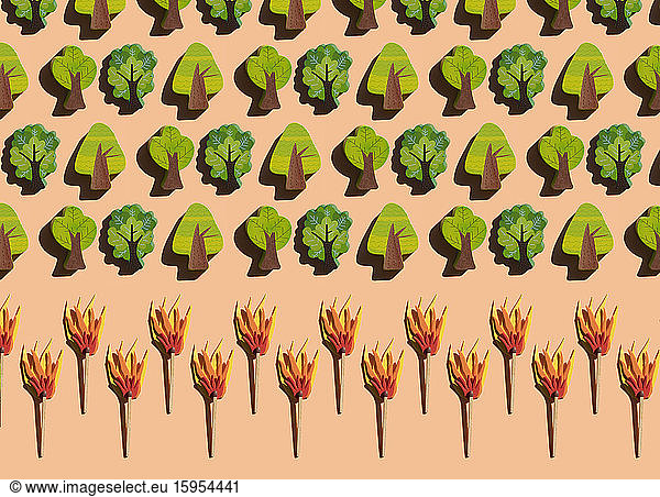 Studioaufnahme von brennenden Streichhölzern  die Reihen kleiner Holzbäume bedrohen