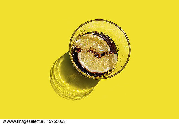 Studioaufnahme von einem Glas Cola mit Zitronenscheiben