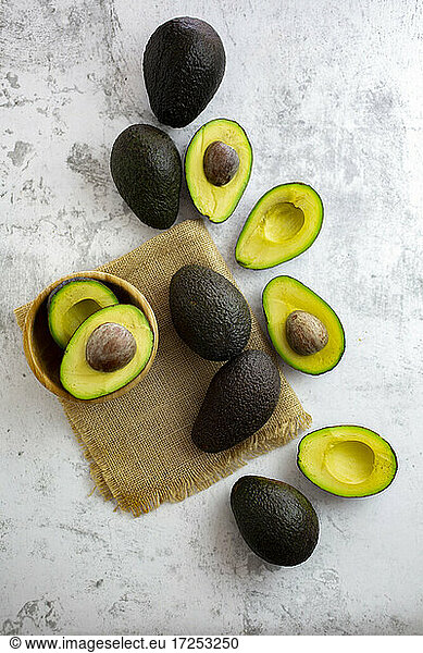 Studioaufnahme von halbierten und ganzen Avocados