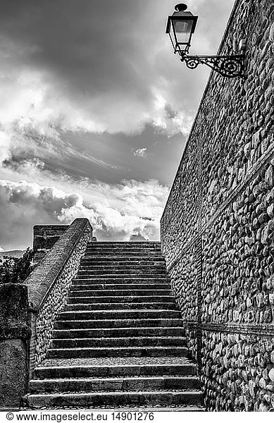 Stufen und eine Steinmauer mit aufgesetztem Licht und bewölktem Himmel; Antequera  Malaga  Spanien