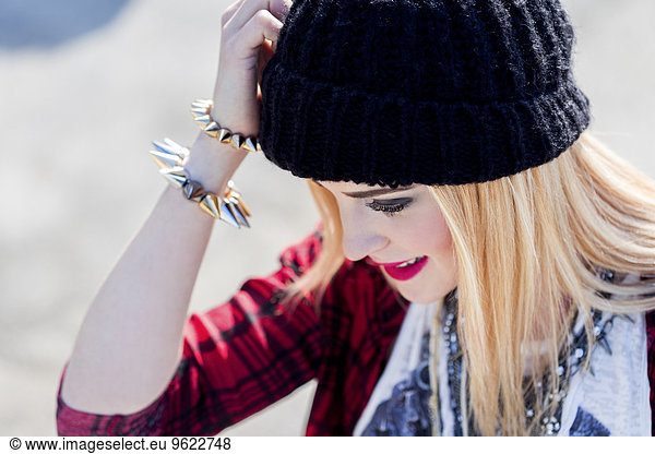 Stylish blond young woman wearing black wool cap