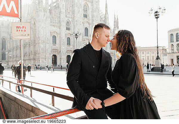 Stylish man and woman in love kissing near Duomo metro station Milan