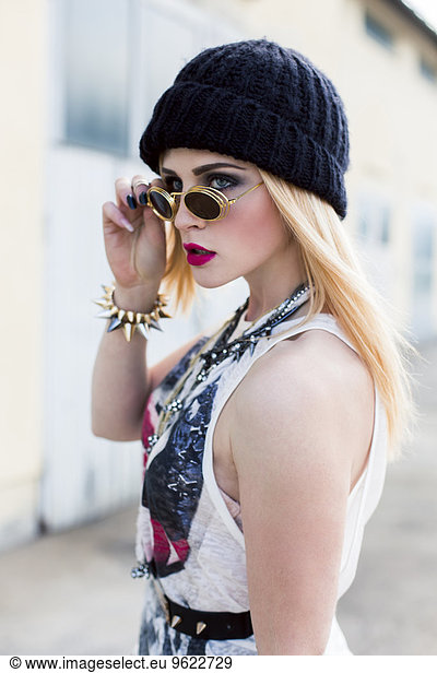 Stylish young woman wearing black wool cap and sunglasses
